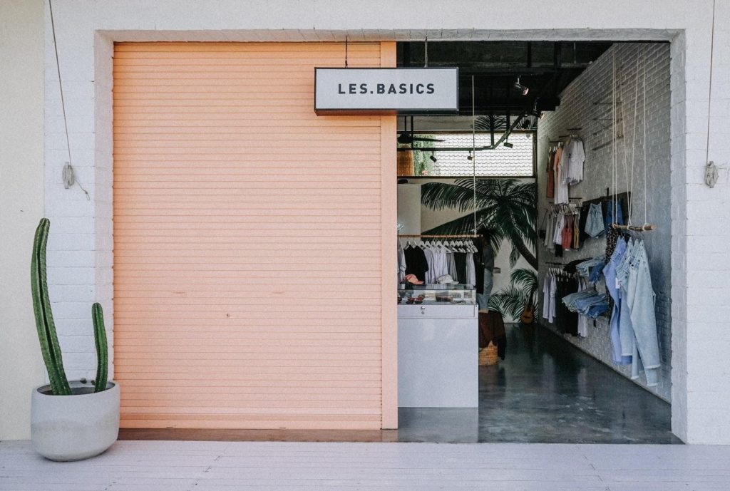Fachada da loja "Les.Basics", com elementos básicos na composição.